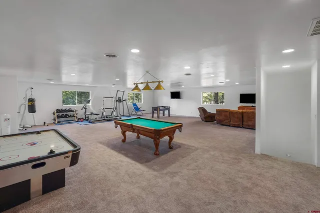 a living room with furniture and a pool table