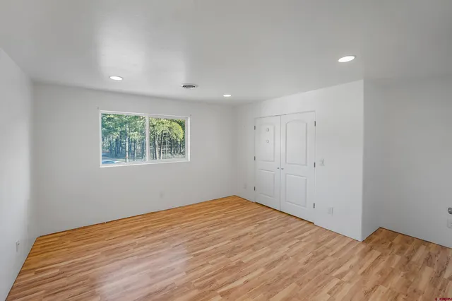 a view of empty room with wooden floor