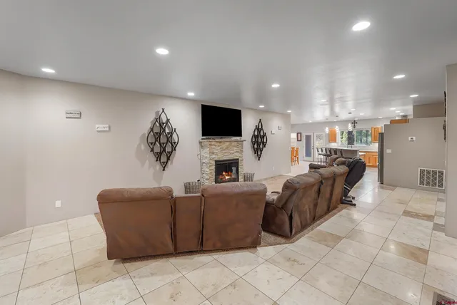 a living room with furniture a fireplace and a flat screen tv
