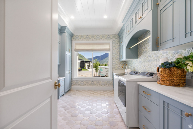 115 East Hidden Ridge Lane, Unit 42 Mapleton, UT 84664 - Photo 32 of 103 Laundry room featuring light blue cabinetry, built-in appliances, patterned wallpaper, a window with a mountain backdrop, and patterned floor tiling