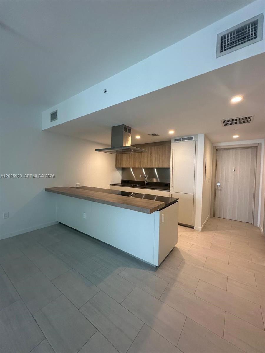 1000 Brickell, Unit 2014 Miami, FL 33131 - Photo 19 of 30 a large kitchen with a large counter top and stainless steel appliances