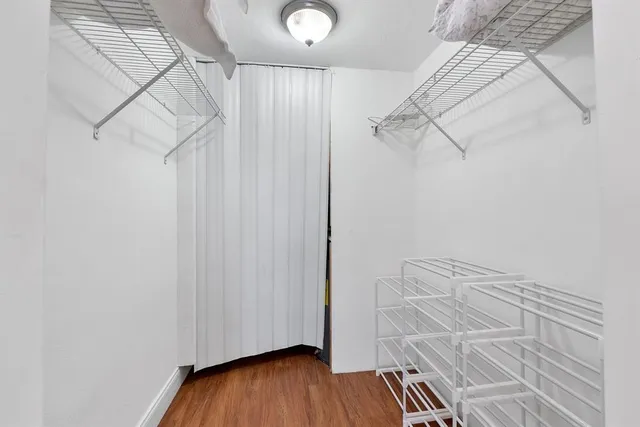 a view of walk in closet with clothes and shoes