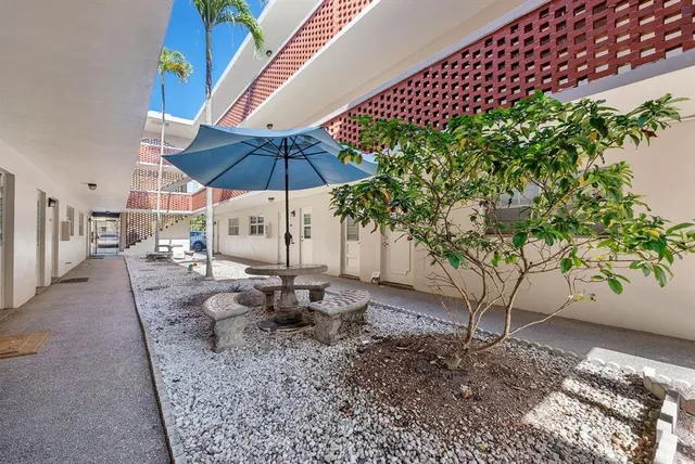 a view of a patio with a table and chairs under an umbrella