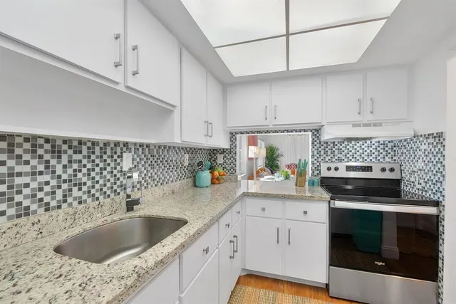 a kitchen with a sink stove and cabinets