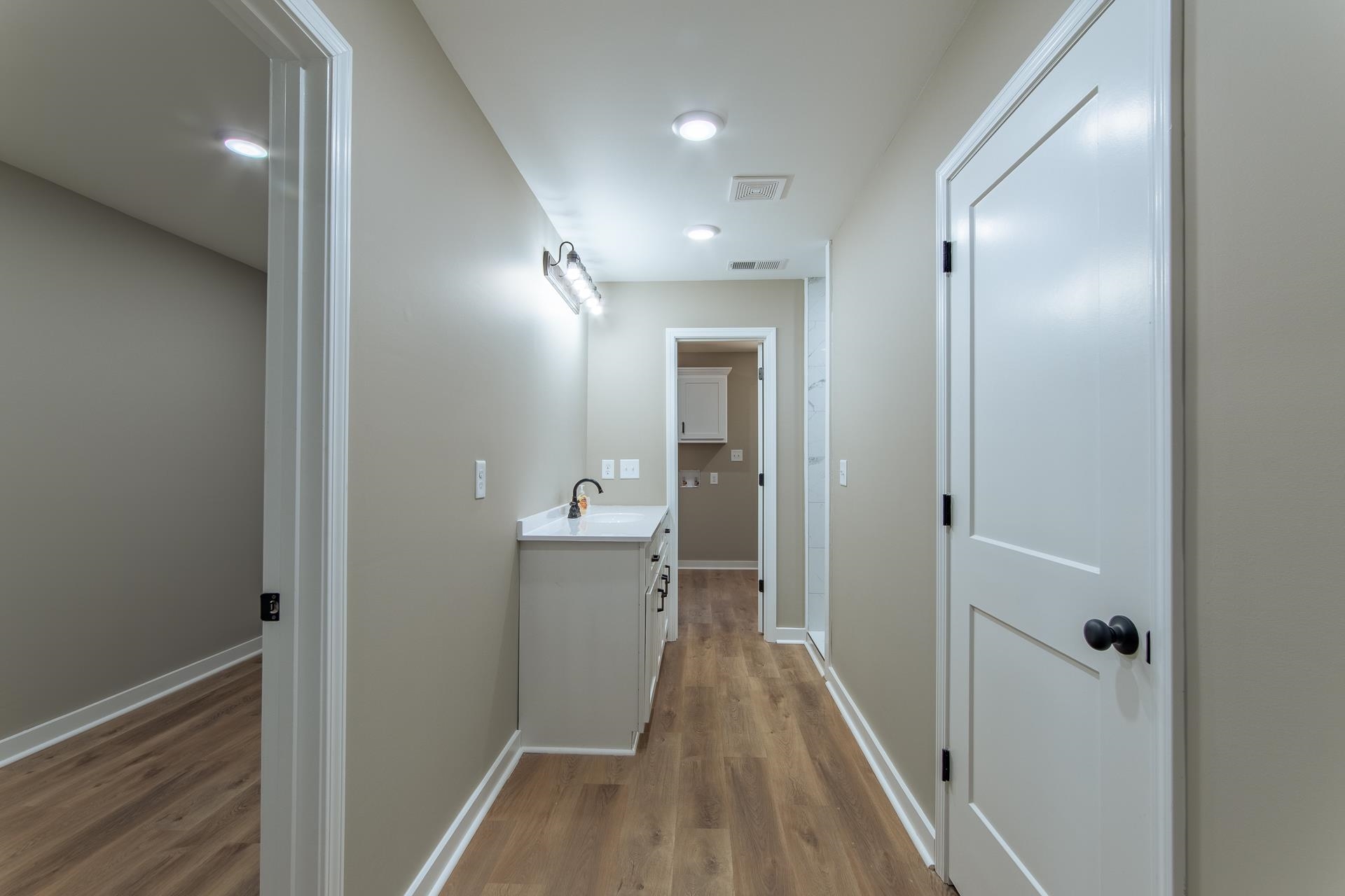 1471 Chambers Store Road Michie, TN 38357 - Photo 13 of 38 Hallway featuring baseboards, visible vents, wood finished floors, and a sink