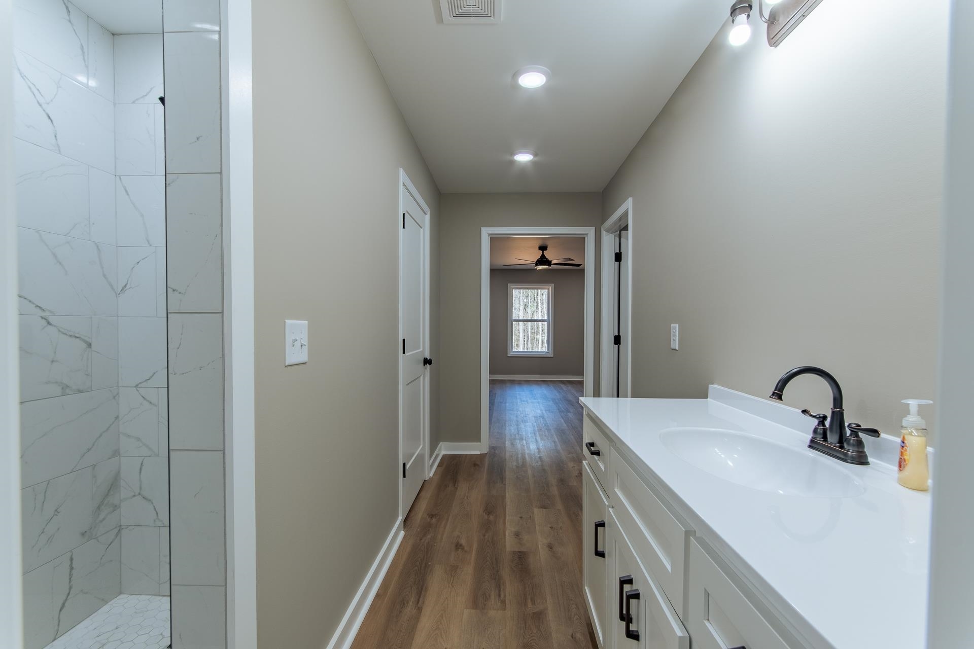 1471 Chambers Store Road Michie, TN 38357 - Photo 17 of 38 Bathroom with vanity, baseboards, a tile shower, and wood finished floors