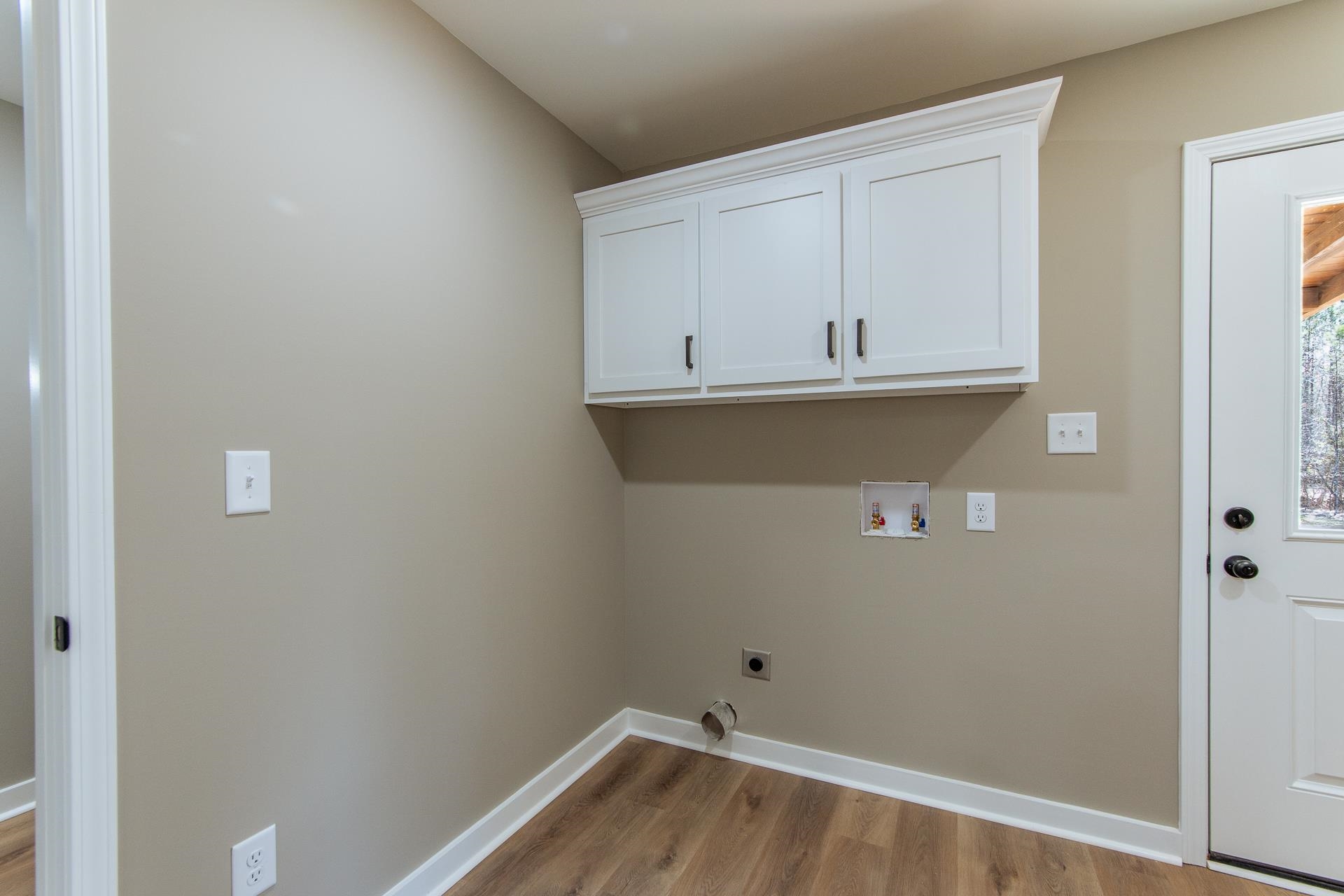 1471 Chambers Store Road Michie, TN 38357 - Photo 20 of 38 Laundry area with wood finished floors, electric dryer hookup, baseboards, cabinet space, and hookup for a washing machine