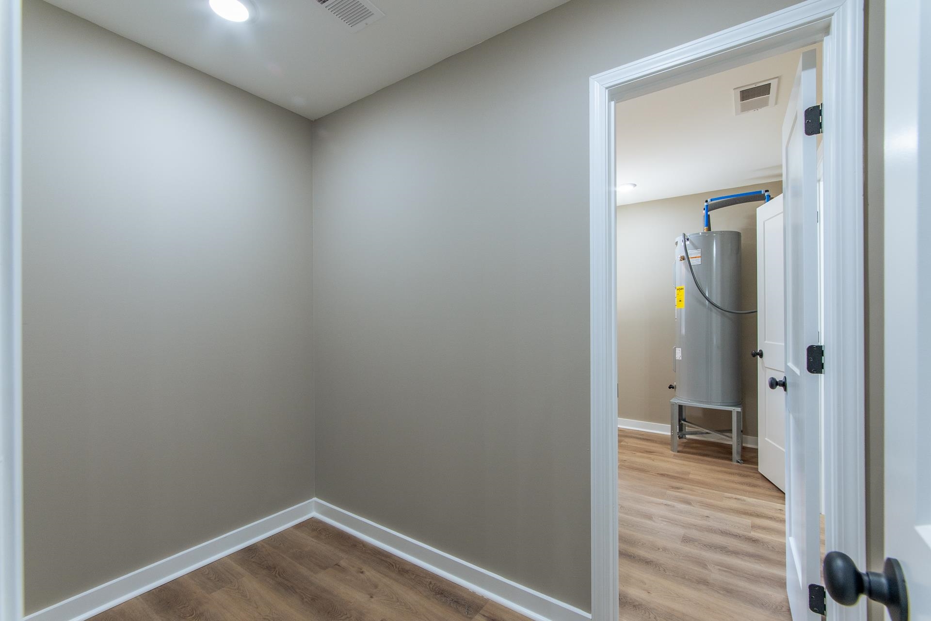 1471 Chambers Store Road Michie, TN 38357 - Photo 21 of 38 Spare room featuring water heater, baseboards, visible vents, and wood finished floors
