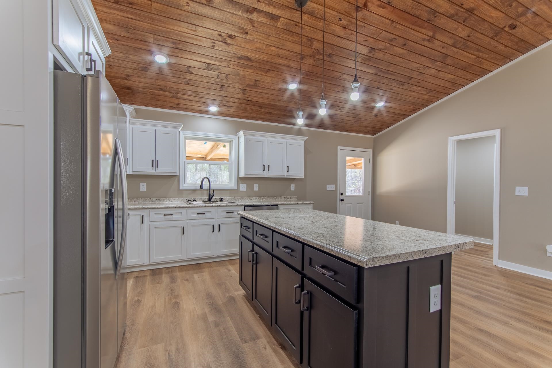 1471 Chambers Store Road Michie, TN 38357 - Photo 7 of 38 Kitchen with white cabinets, a sink, stainless steel fridge with ice dispenser, a center island, and wood ceiling