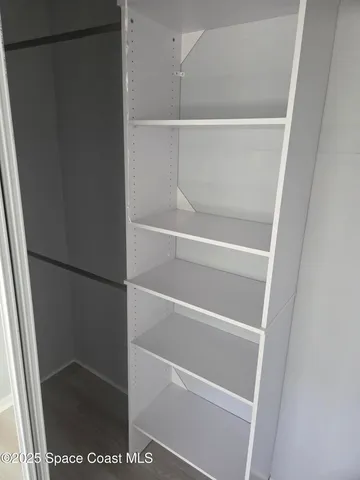 a view of walk in closet with empty racks
