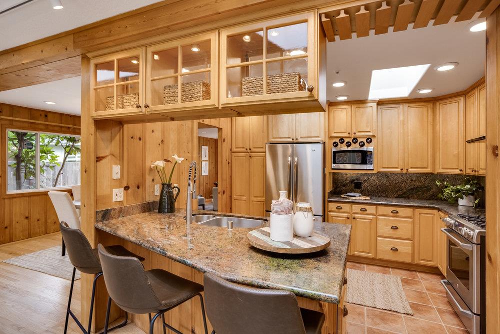1067 Rio Vista Drive Pacifica, CA 94044 - Photo 7 of 43 a kitchen with stainless steel appliances kitchen island granite countertop a table and chairs in it
