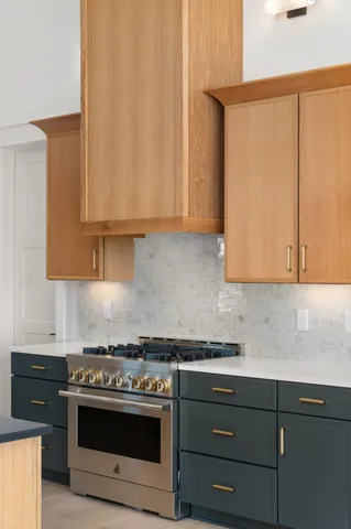 a kitchen with stainless steel appliances granite countertop a sink a stove and a wooden floor