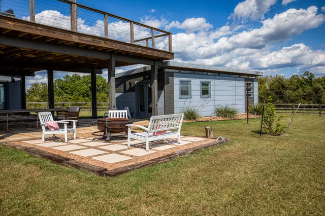 an outdoor living room with patio furniture and a floor to ceiling window