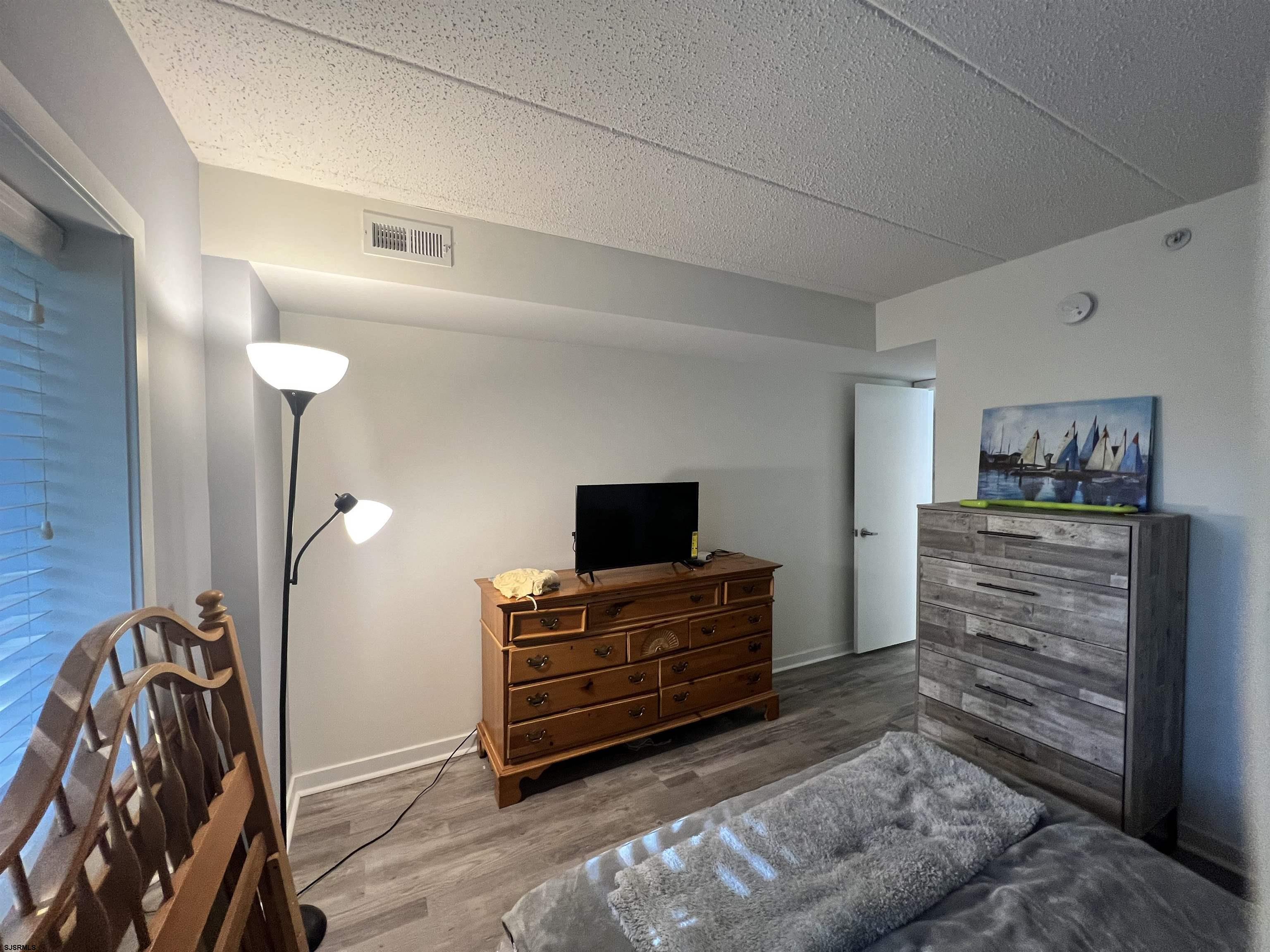 4310 Dolphin Avenue, Unit 4310 Northfield, NJ 08225 - Photo 12 of 21 a living room with furniture and a flat screen tv