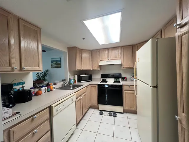 a kitchen with a refrigerator a stove top oven and cabinets