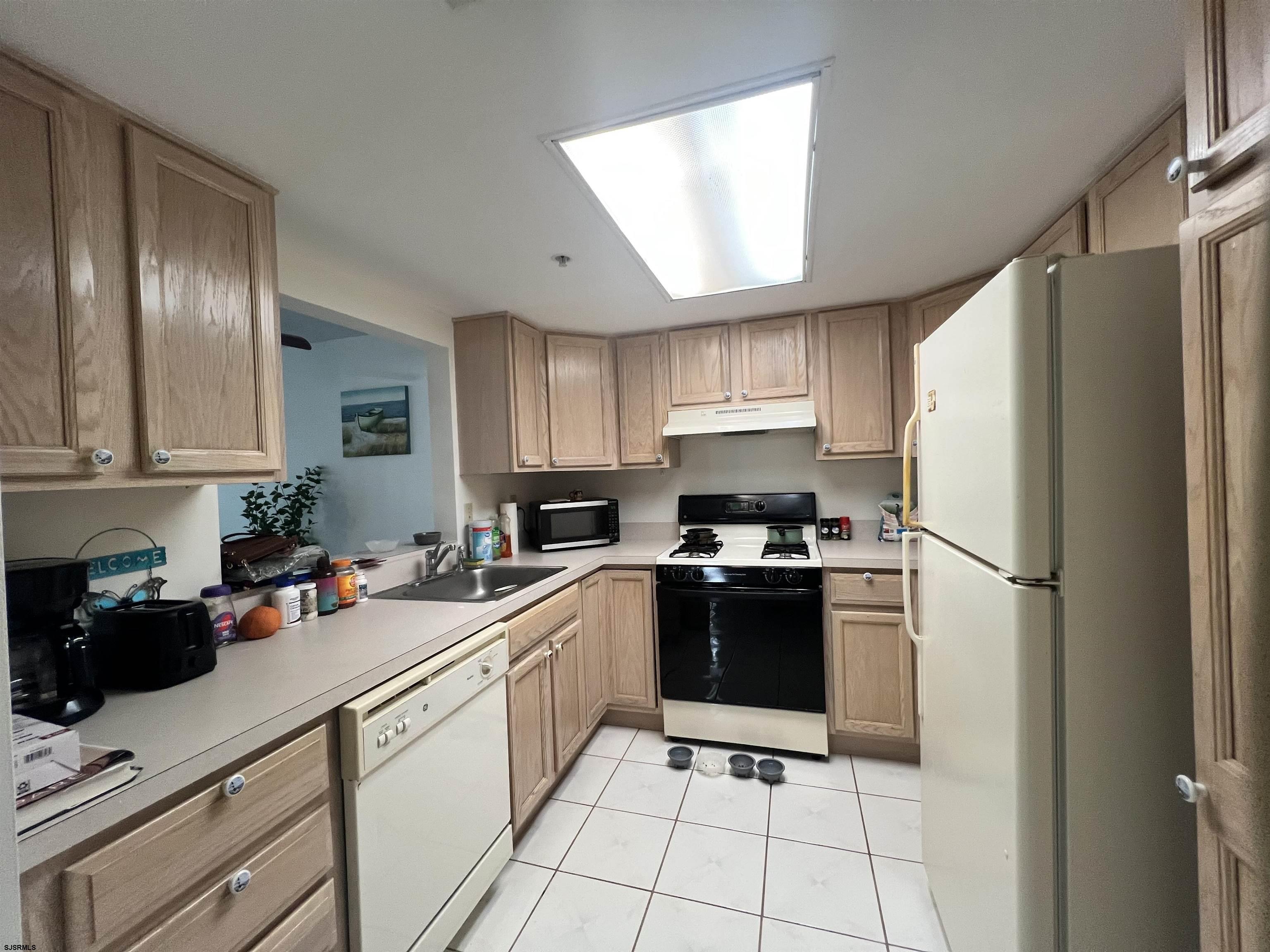 4310 Dolphin Avenue, Unit 4310 Northfield, NJ 08225 - Photo 9 of 21 a kitchen with stainless steel appliances a refrigerator sink and cabinets