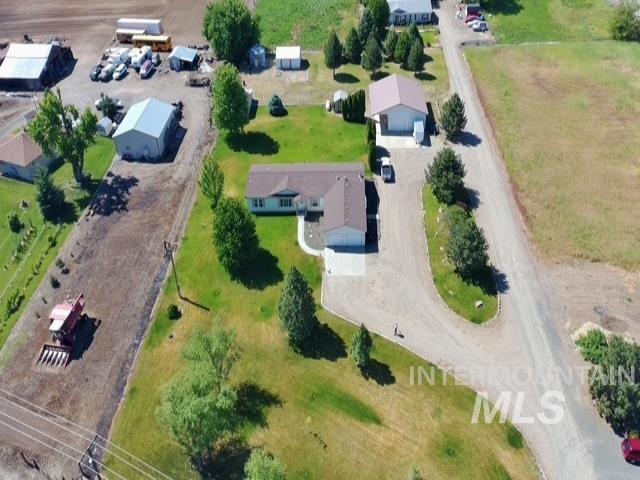 1095 County Road 70 Weiser, ID 83672 - Photo 44 of 44 Ranch-style residence featuring an attached garage, a detached garage, and a separate outbuilding, all surrounded by expansive green lawns and mature trees