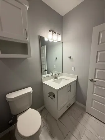 a bathroom with a sink mirror vanity and toilet