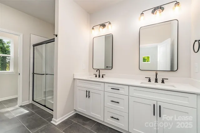 a bathroom with double vanity sinks and a mirror