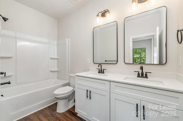 a bathroom with a toilet a sink a bathtub and a mirror