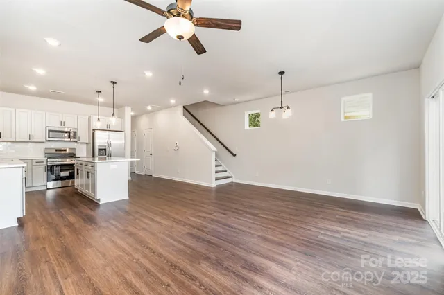 a view of a kitchen with wooden floor and stainless steel appliances