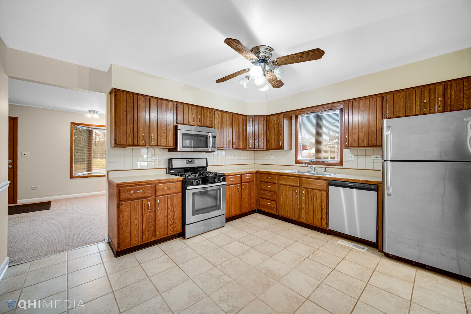 2402 Wing Street Rolling Meadows, IL 60008 - Photo 7 of 20 a large kitchen with stainless steel appliances granite countertop a refrigerator a stove top oven and a sink