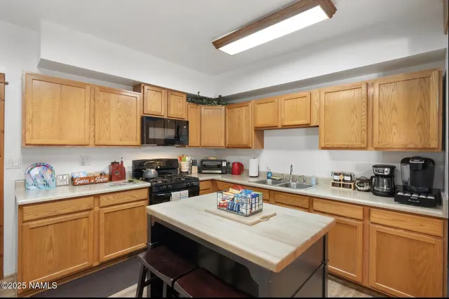 a kitchen with stainless steel appliances granite countertop a sink stove refrigerator and cabinets