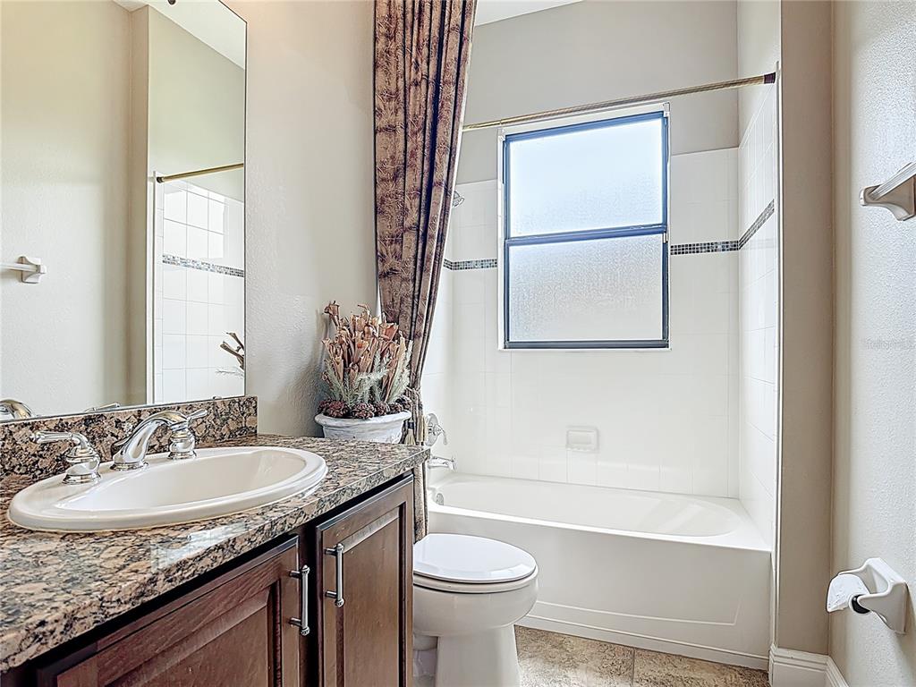 772 San Raphael Street Kissimmee, FL 34759 - Photo 35 of 94 a bathroom with a granite countertop sink toilet and a mirror