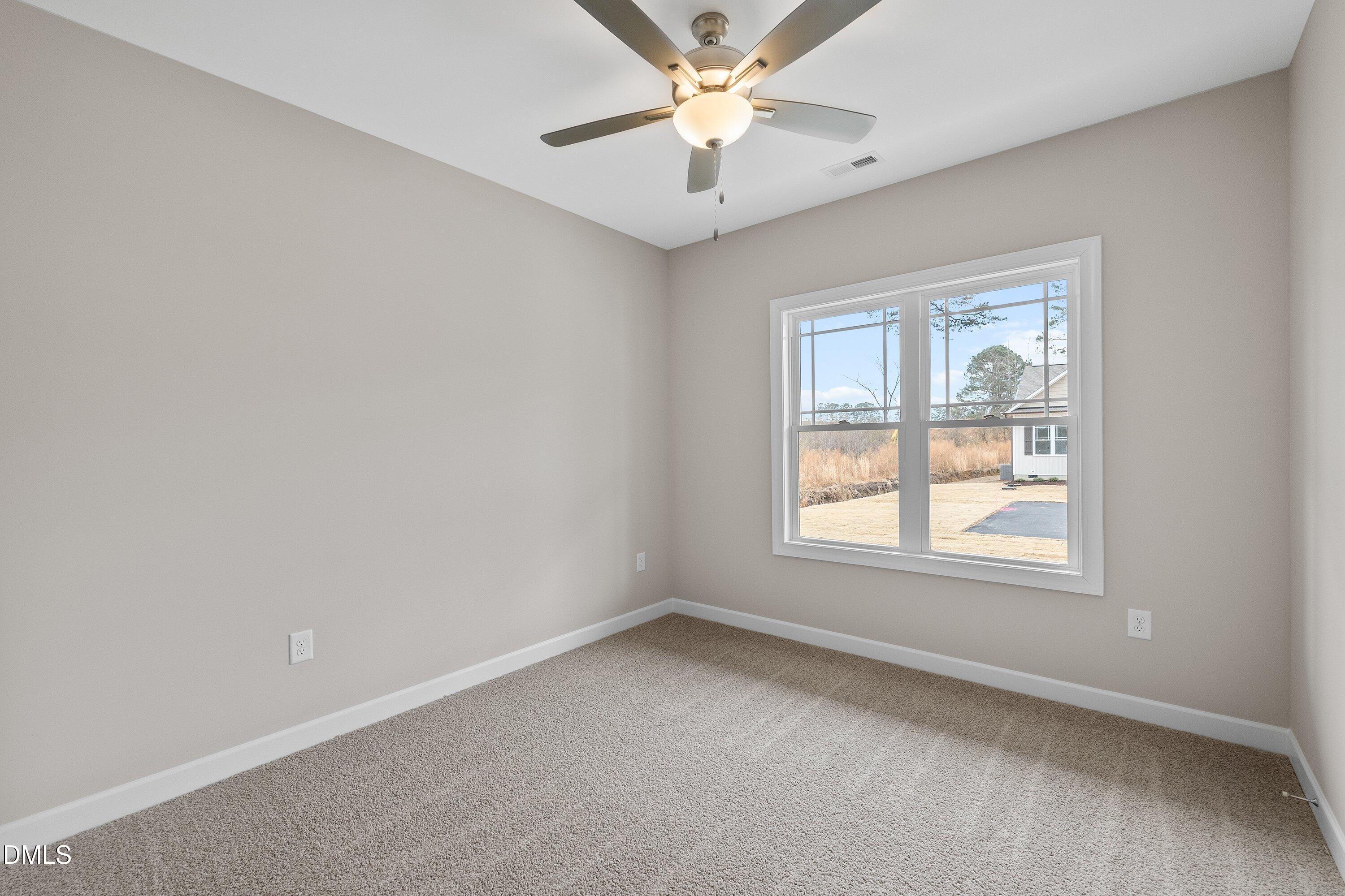 926 Micro Road West Selma, NC 27576 - Photo 27 of 41 an empty room with a window and a fan