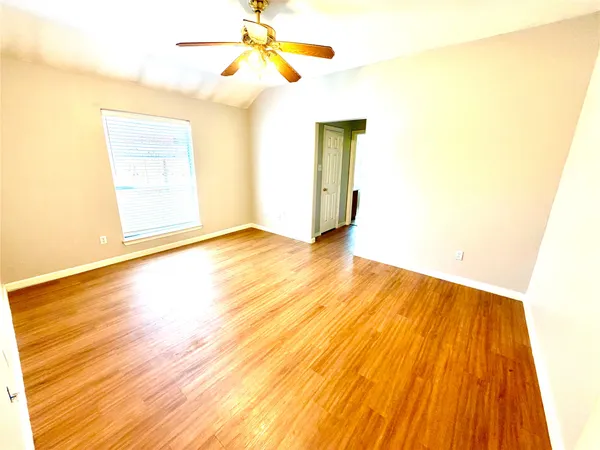 a view of a room with wooden floor and a ceiling fan
