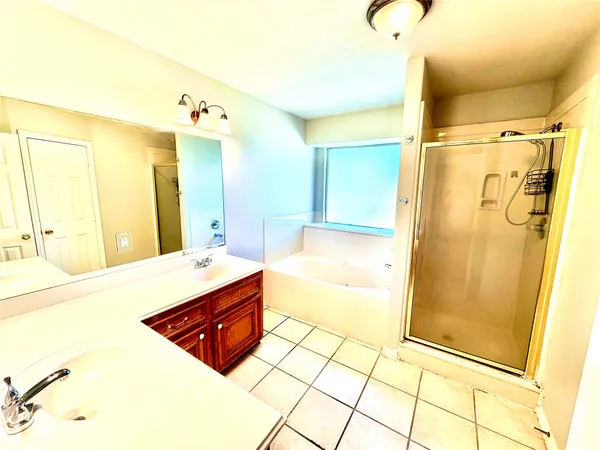 a spacious bathroom with a tub shower and sink