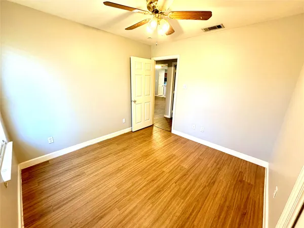 a view of an empty room with wooden floor
