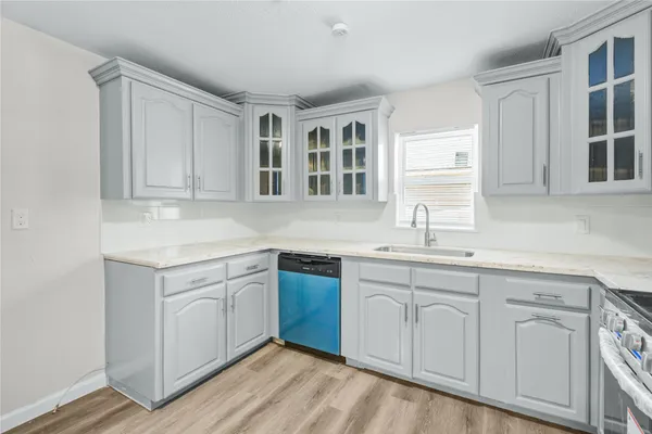 a kitchen with white cabinets and sink