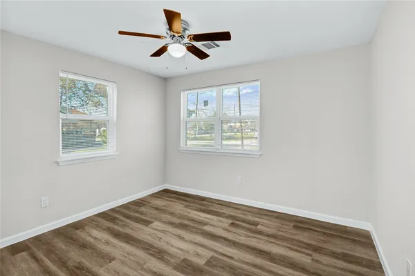 a view of empty room with wooden floor