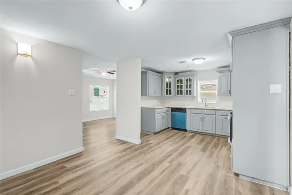 a room with a wooden floor and windows