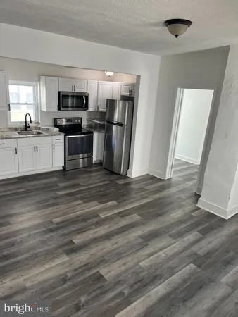 a view of kitchen with stainless steel appliances refrigerator stove microwave and cabinets