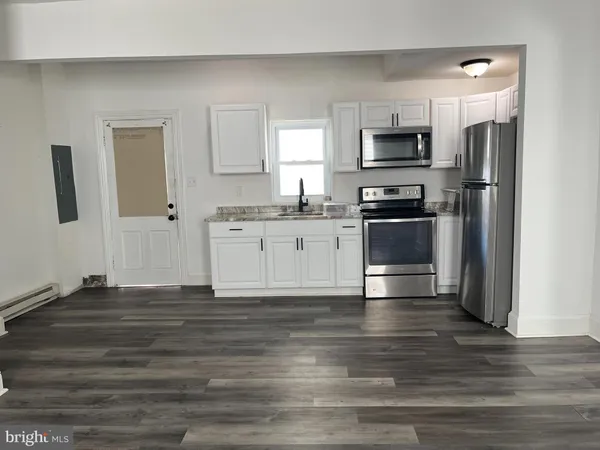 a kitchen with granite countertop a refrigerator stove and microwave