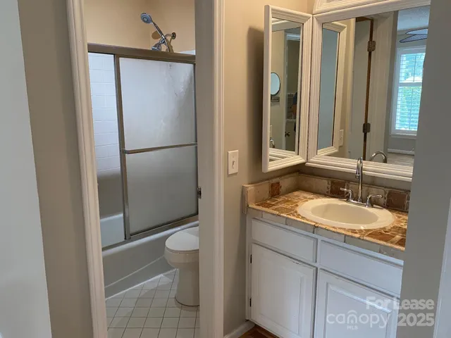 a bathroom with a granite countertop sink toilet and shower