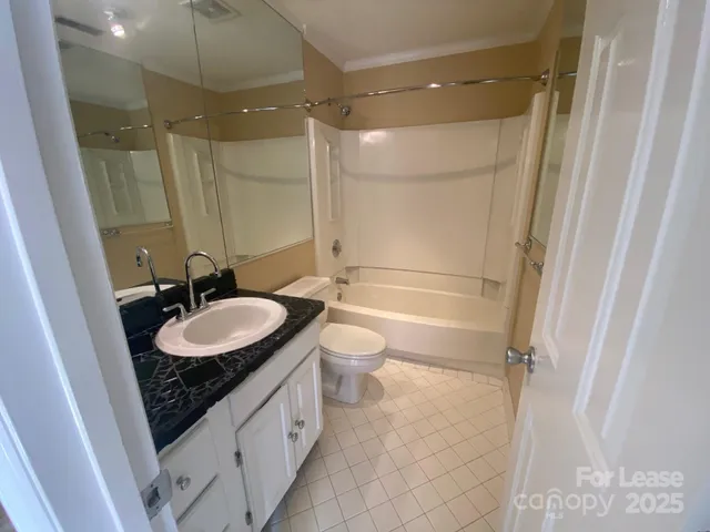 a bathroom with a double vanity sink toilet mirror and shower