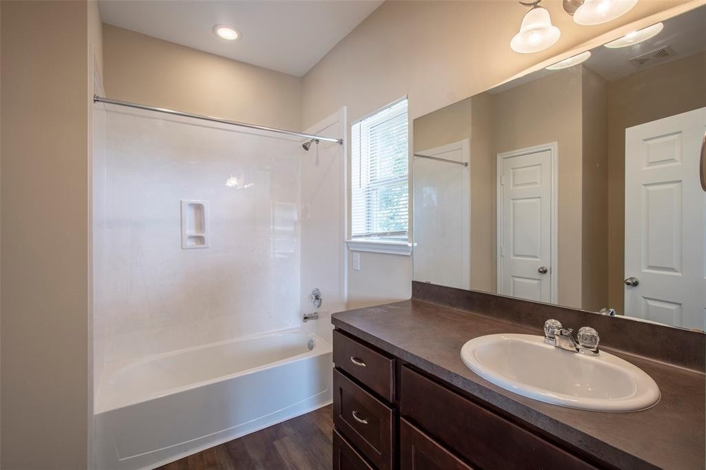 8142 Cabot Street, Unit A Houston, TX 77078 - Photo 11 of 21 a bathroom with a sink double vanity mirror and a bathtub