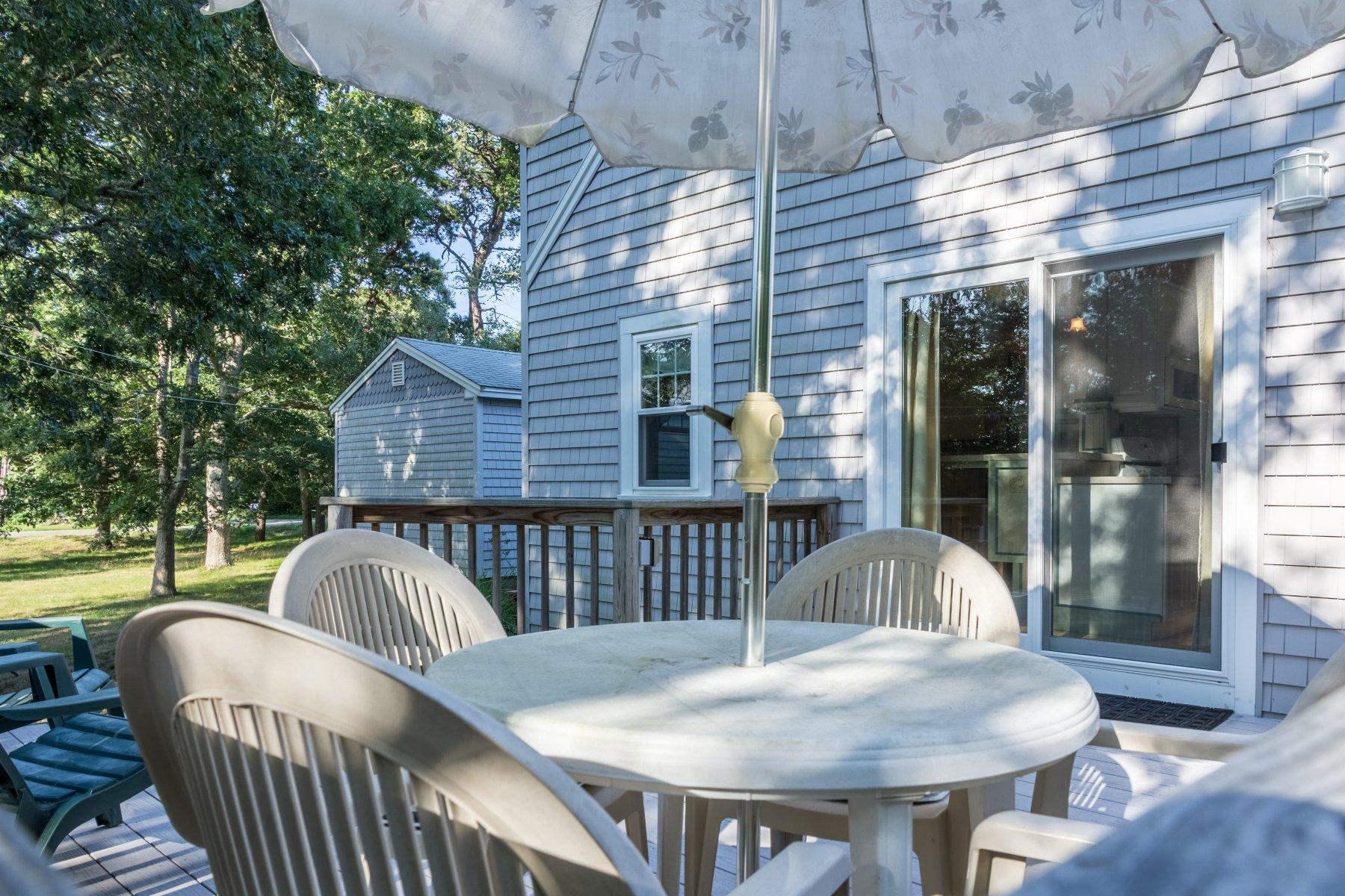 2 Otis Kelly Road Dennis Port, MA 02639 - Photo 5 of 23 a view of a patio with a table chairs and a potted plant