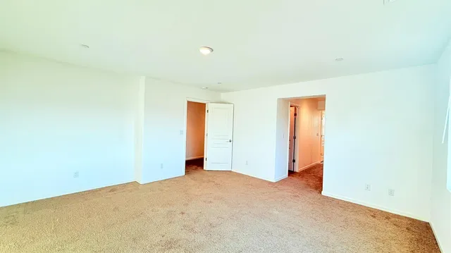 a view of a hallway with wooden floor and entryway