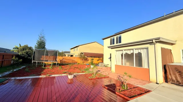 a view of house with backyard and a tree