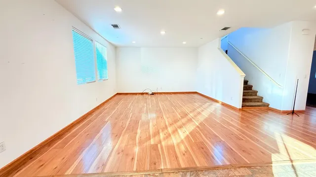 a view of an empty room with wooden floor