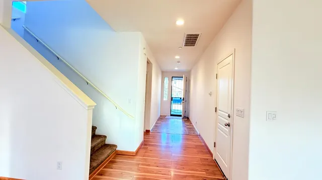 a view of a hallway with wooden floor