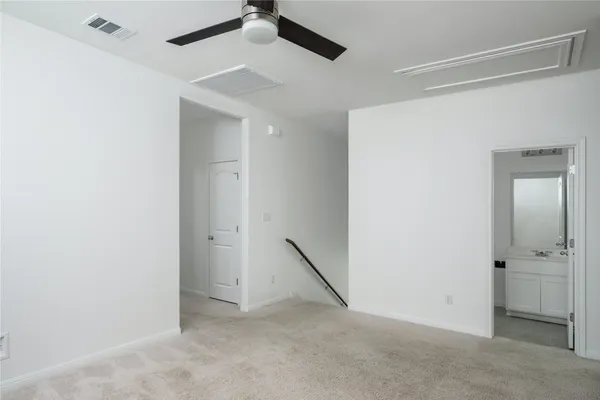 an empty room with a ceiling fan and entryway