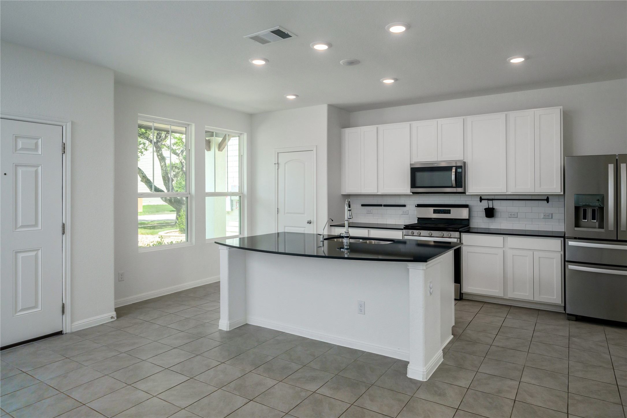2540 Acoma Lane Leander, TX 78641 - Photo 3 of 26 a kitchen with stainless steel appliances granite countertop a stove a sink and a microwave