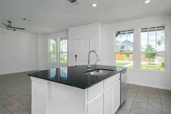 a kitchen with granite countertop a sink and a stove