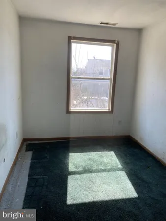 an empty room with wooden floor and window