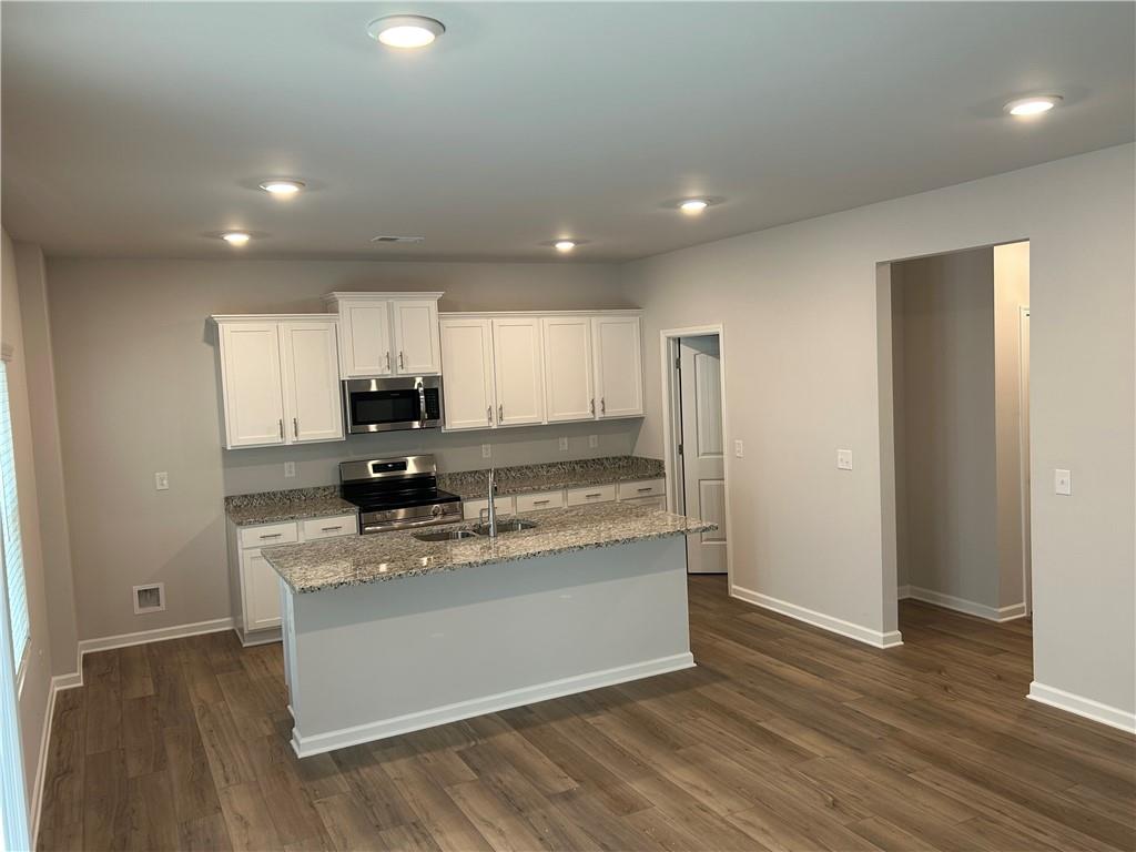 27 Stonebrook Drive Rome, GA 30165 - Photo 5 of 22 a large kitchen with stainless steel appliances granite countertop a stove a sink and a refrigerator with wooden floors